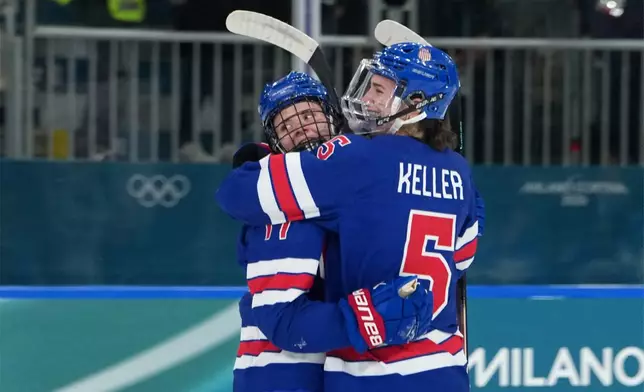 United States' Britta Curl (17) celebrates with Megan Keller (5) after Curl scored a goal against Italy during the second period of a women's ice hockey quarterfinal match at the 2026 Winter Olympics, in Milan, Italy, Friday, Feb. 13, 2026. (AP Photo/Carolyn Kaster)