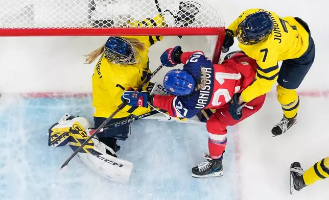Czechia's Tereza Vanisova (21) challenges with Sweden's Ebba Svensson Traff (1) during a women's quarterfinal game between Czechia and Sweden at the 2026 Winter Olympics, in Milan, Italy, Friday, Feb. 13, 2026. (AP Photo/Darko Bandic)