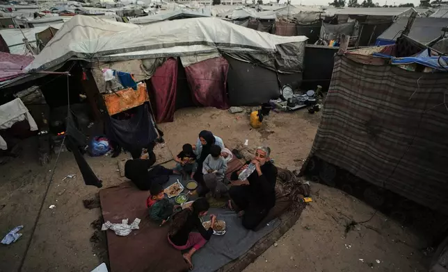 Displaced members of the Al-Zamli family break their fast on the first day of Ramadan inside their tent in Khan Younis, Gaza Strip, Wednesday, Feb. 18, 2026. (AP Photo/Jehad Alshrafi)
