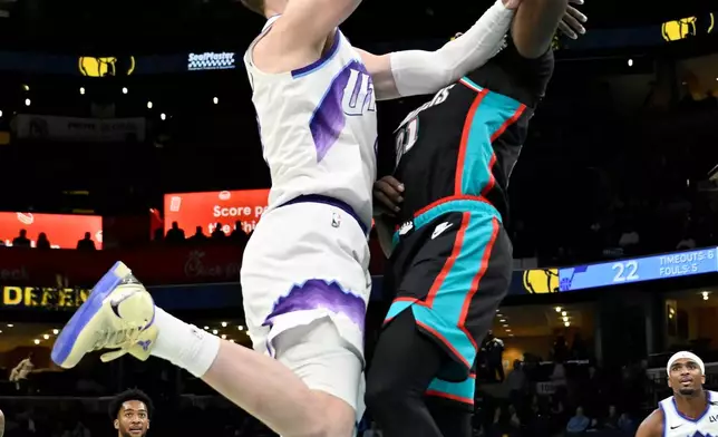 Utah Jazz forward Kyle Filipowski, left, shoots against Memphis Grizzlies guard Jahmai Mashack (21) in the first half of an NBA basketball game Friday, Feb. 20, 2026, in Memphis, Tenn. (AP Photo/Brandon Dill)