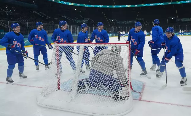 Members of the United States men's ice hockey team including Brady Tkachuk, third from right, Auston Matthews, second from right, and United States' Jack Hughes, right, gather around the net during men's ice hockey practice at the 2026 Winter Olympics, in Milan, Italy, Sunday, Feb. 8, 2026. (AP Photo/Carolyn Kaster)