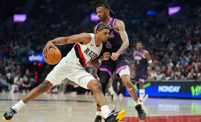 Portland Trail Blazers guard Scoot Henderson, left, drives to the basket as Minnesota Timberwolves guard Bones Hyland (8) defends during the first half of an NBA basketball game, Tuesday, Feb. 24, 2026, in Portland, Ore. (AP Photo/Jenny Kane)