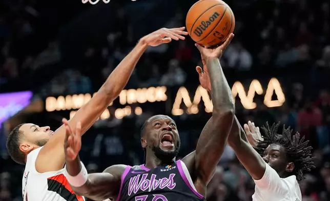 Minnesota Timberwolves forward Julius Randle (30) shoots as Portland Trail Blazers forward Kris Murray, left, and guard Sidy Cissoko, right, defend during the second half of an NBA basketball game Tuesday, Feb. 24, 2026, in Portland, Ore. (AP Photo/Jenny Kane)