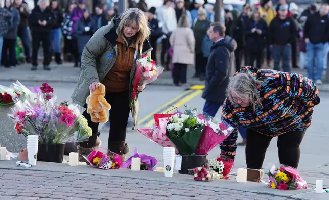 People bring flowers and stuffed animal to a vigil for the victims of a mass shooting, in Tumbler Ridge, B.C., Friday, Feb. 13, 2026. (Christinne Muschi/The Canadian Press via AP)