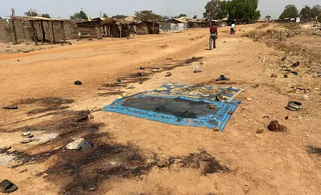 Blood stains cover the ground, days after an attack on the village of Woro, Nigeria, Thursday, Feb. 5, 2026. (AP Photo/ Musa Salim)