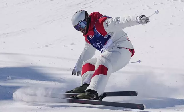 Canada's Mikael Kingsbury (4) celebrates after winning the gold medal during the men's freestyle skiing dual moguls finals at the 2026 Winter Olympics, in Livigno, Italy, Sunday, Feb. 15, 2026. (AP Photo/Gregory Bull)