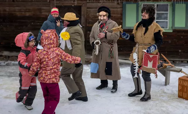 Revelers wearing traditional carnival masks dance during Shrovetide celebrations in the village of Rumsiskes, some 89 kilometers (56 miles) north of Vilnius, Lithuania, Saturday, Feb. 14, 2026. (AP Photo/Mindaugas Kulbis)