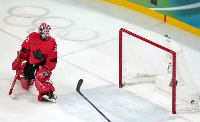 Canada goalkeeper Jordan Binnington looks back at the net as a shot by United States' Jack Hughes gets past for the winning goal in the overtime period of the men's ice hockey gold medal game at the 2026 Winter Olympics in Milan, Italy, Sunday, Feb. 22, 2026. (AP Photo/Carolyn Kaster)