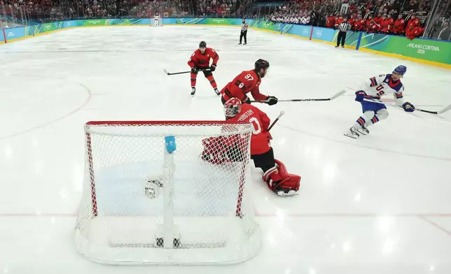 United States' Jack Hughes (86) scores the game-winning goal against Canada's Connor McDavid (97) and Jordan Binnington (50) in overtime during a men's ice hockey gold medal game between Canada and the United States at the 2026 Winter Olympics, in Milan, Italy, Sunday, Feb. 22, 2026. (Bruce Bennett/Pool Photo via AP)