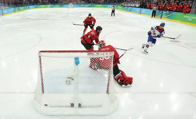 United States' Jack Hughes (86) scores the game winning goal against Canada's Connor McDavid (97) and Jordan Binnington (50) in overtime during a men's ice hockey gold medal game between Canada and the United States at the 2026 Winter Olympics, in Milan, Italy, Sunday, Feb. 22, 2026. (Bruce Bennett/Pool Photo via AP)