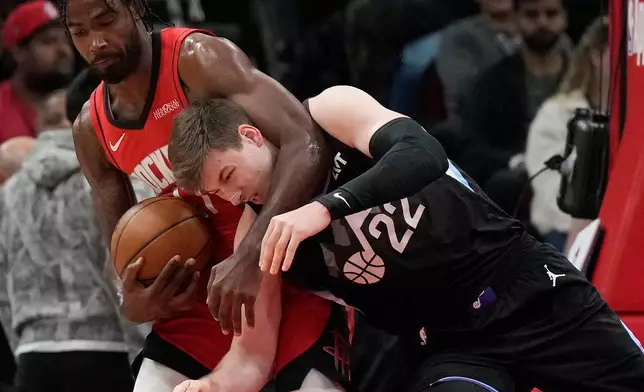 Houston Rockets forward Tari Eason, left, grabs a rebound against Utah Jazz forward Kyle Filipowski (22) during the first half of an NBA basketball game, Monday, Feb. 23, 2026, in Houston. (AP Photo/Karen Warren)