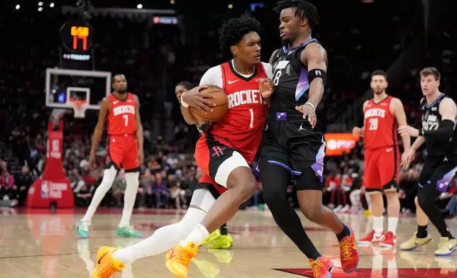 Houston Rockets guard Amen Thompson (1) controls the ball against Utah Jazz guard Isaiah Collier (8) during the first half of an NBA basketball game, Monday, Feb. 23, 2026, in Houston. (AP Photo/Karen Warren)