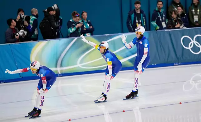 Team USA with Ethan Cepuran, white armband, Casey Dawson, red armband, and Emery Lehman, yellow armband, celebrates after winning the semifinal of the men's team pursuit speedskating race at the 2026 Winter Olympics, in Milan, Italy, Tuesday, Feb. 17, 2026. (AP Photo/Ben Curtis)