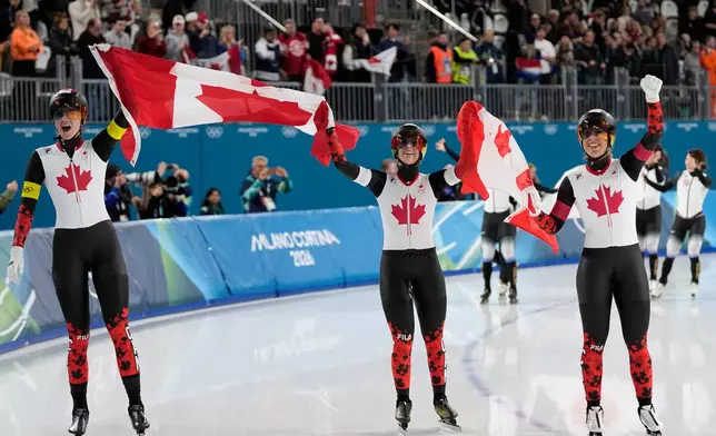 Team Canada with Ivanie Blondin, white armband, Valerie Maltais, red armband, Isabelle Weidemann, yellow armband, celebrate winning the gold medal in the final of the women's team pursuit speedskating race at the 2026 Winter Olympics, in Milan, Italy, Tuesday, Feb. 17, 2026. (AP Photo/Ben Curtis)