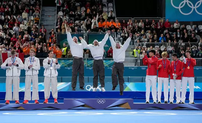 Team Italy, center and goal medal, team USA, left and silver medal, and team China celebrate on the podium of the men's team pursuit speedskating race at the 2026 Winter Olympics, in Milan, Italy, Tuesday, Feb. 17, 2026. (AP Photo/Ben Curtis)