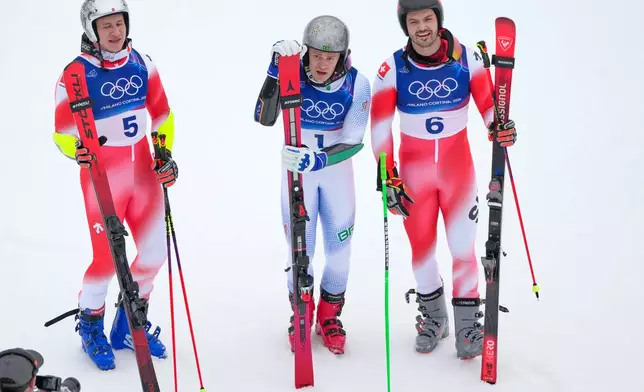 Brazil's Lucas Pinheiro Braathen,center, winner of an alpine ski, men's giant slalom race, poses with second placed Switzerland's Marco Odermatt, left, and third placed Switzerland's Loic Meillard, at the 2026 Winter Olympics, in Bormio, Italy, Saturday, Feb. 14, 2026. (AP Photo/John Locher)