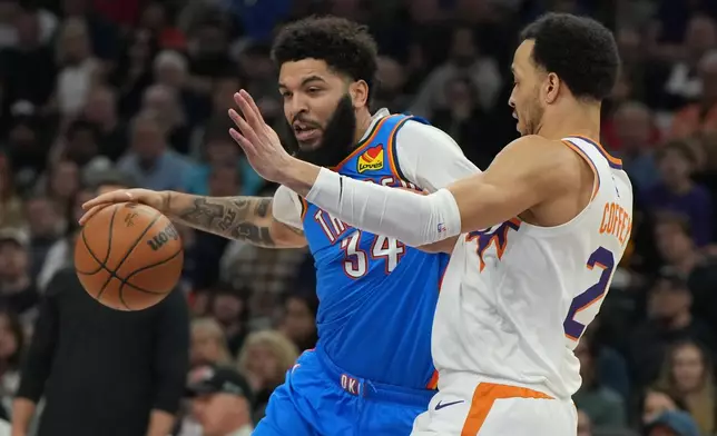 Oklahoma City Thunder guard Kenrich Williams (34) drives on Phoenix Suns guard Amir Coffey during the first half of an NBA basketball game, Wednesday, Feb. 11, 2026, in Phoenix. (AP Photo/Rick Scuteri)