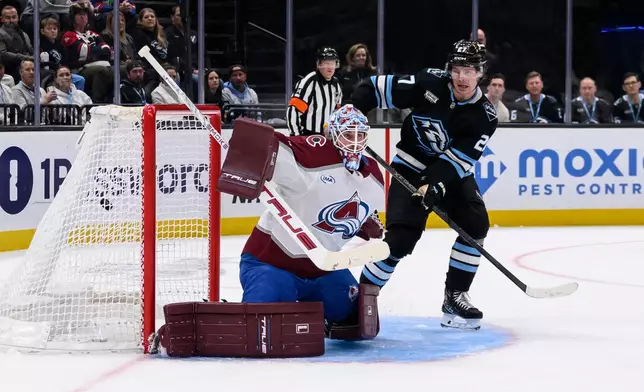 The puck goes into the net past Colorado Avalanche goaltender Scott Wedgewood, left, from a shot by Utah Mammoth right wing Dylan Guenther, not pictured, during the second period of an NHL hockey game, Wednesday, Feb. 25, 2026, in Salt Lake City. (AP Photo/Tyler Tate)