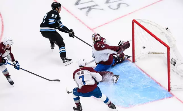 Colorado Avalanche goaltender Scott Wedgewood (41) reaches his glove behind his back to block the shot of Utah Mammoth center Barrett Hayton (27) during the first period of an NHL hockey game, Wednesday, Feb. 25, 2026, in Salt Lake City. (AP Photo/Tyler Tate)