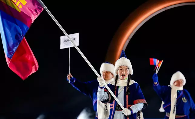 Ariuntungalag Enkhbayar, the flag bearer of Mongolia, takes part in the athletes parade during the Olympic opening ceremony at the 2026 Winter Olympics, in Predazzo, Italy, Friday, Feb. 6, 2026. (AP Photo/Matthias Schrader)