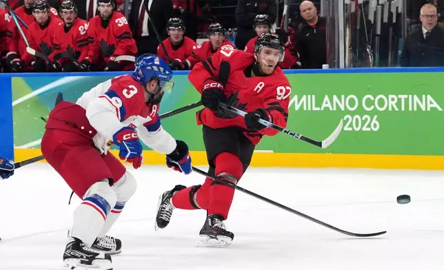Canada's Connor McDavid (97) takes a shot as he is defended by Czechia's Radko Gudas (3) during the second period of a men's ice hockey quarterfinal game at the 2026 Winter Olympics, in Milan, Italy, Wednesday, Feb. 18, 2026. (AP Photo/Carolyn Kaster)