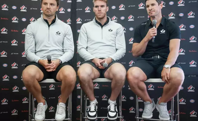 FILE - Team Canada hockey players, left to right, Sam Reinhart, Connor McDavid and Sidney Crosby speak to the media at Hockey Canada's National Teams orientation camp in Calgary, Alberta, Wednesday, Aug. 27, 2025. (Jeff McIntosh/The Canadian Press via AP, File)