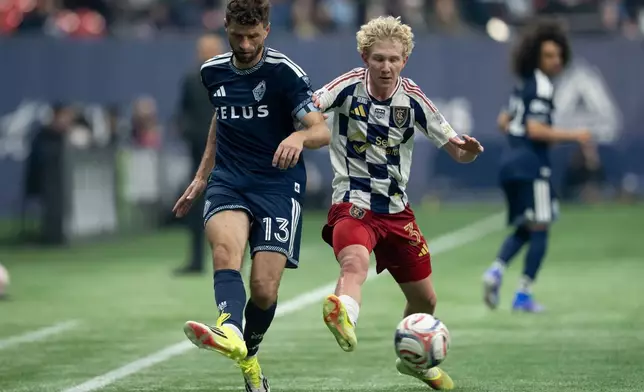 Vancouver Whitecaps' Thomas Muller (13) and Real Salt Lake's Luca Moisa (34) vie for the ball during the first half of an MLS soccer match in Vancouver, on Saturday, Feb. 21, 2026. (Ethan Cairns/The Canadian Press via AP)