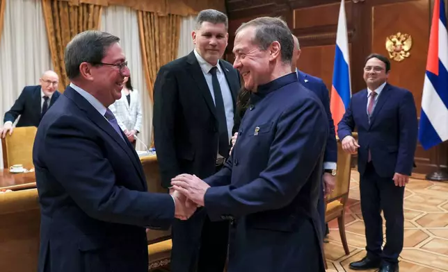 Cuban Foreign Minister Bruno Rodriguez, left, and Russian Security Council Deputy Chairman and the head of the United Russia party Dmitry Medvedev, foreground right, greet each other prior to their talks in Moscow, Wednesday, Feb. 18, 2026. (Ekaterina Shtukina, Sputnik Pool Photo via AP)