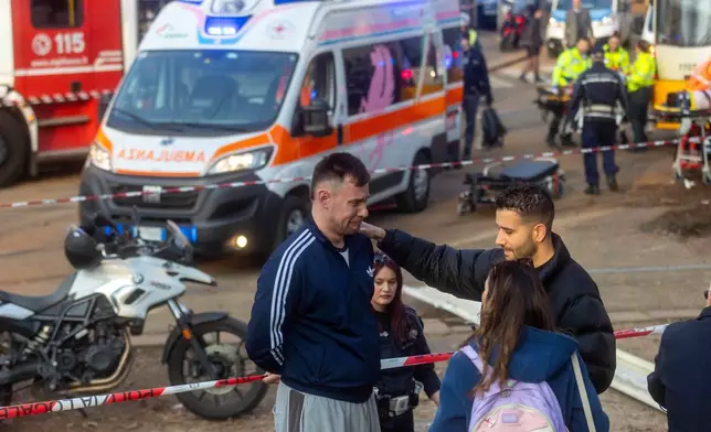 A person reacts at the scene of a derailment on Line 9 in Milan, Italy, Friday, Feb. 27, 2026. (Stefano Porta/LaPresse via AP)