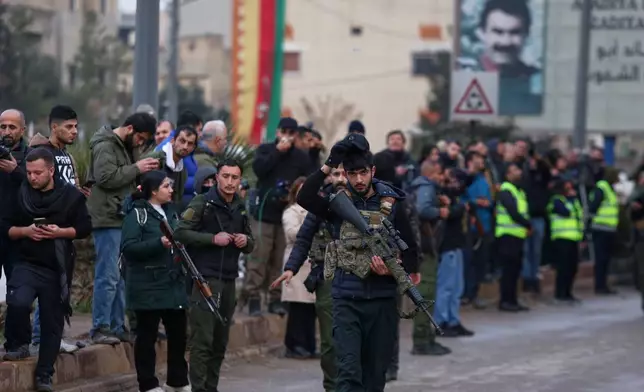 Kurdish-led Syrian Democratic Forces (SDF) combatants secure the area for the arrival of Syria's Interior Ministry security forces, deployed under an agreement aimed at stabilizing a ceasefire, in Qamishli, eastern Syria, Tuesday, Feb. 3, 2026. (AP Photo/Baderkhan Ahmad)