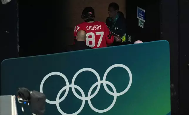 Canada's Sidney Crosby (87) is led away from the ice after being injured during the second period of a men's ice hockey quarterfinal game between Canada and Czechia at the 2026 Winter Olympics, in Milan, Italy, Wednesday, Feb. 18, 2026. (AP Photo/Hassan Ammar)