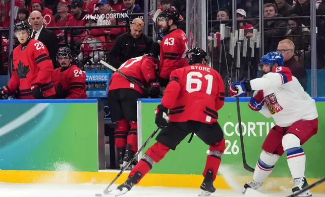 Canada's Sidney Crosby (87) is helped as he leaves the bench after being checked against the boards during the second period of a men's ice hockey quarterfinal game between Canada and Czechia at the 2026 Winter Olympics, in Milan, Italy, Wednesday, Feb. 18, 2026. (AP Photo/Carolyn Kaster)