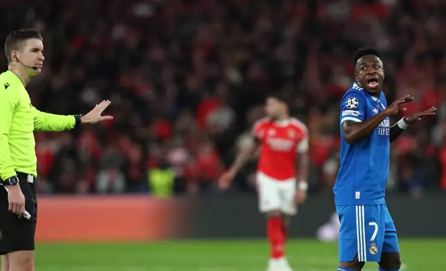 Real Madrid's Vinicius Junior argues with referee François Letexier after scoring the opening goal during a Champions League playoff soccer match between SL Benfica and Real Madrid in Lisbon, Portugal, Tuesday, Feb. 17, 2026. (AP Photo/Pedro Rocha)