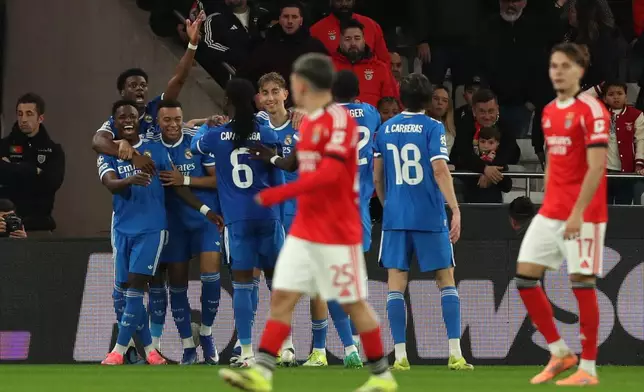 Real Madrid's Vinicius Junior celebrates with team mates the opening goal during a Champions League playoff soccer match between SL Benfica and Real Madrid in Lisbon, Portugal, Tuesday, Feb. 17, 2026. (AP Photo/Pedro Rocha)