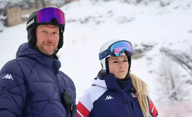 United States' Lindsey Vonn and coach Aksel Lund Svindal, left, ahead of an alpine ski, women's downhill official training, at the 2026 Winter Olympics, in Cortina d'Ampezzo, Italy, Friday, Feb. 6, 2026. (AP Photo/Marco Trovati)