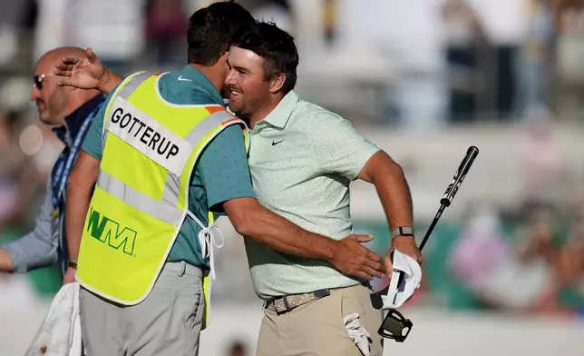 Chris Gotterup, right, smiles as he gets a hug from his caddie Brady Stockton after Gotterup's playoff win at the 18th hole during the final round of the Phoenix Open golf tournament Sunday, Feb. 8, 2026, in Scottsdale, Ariz. (AP Photo/Ross D. Franklin)