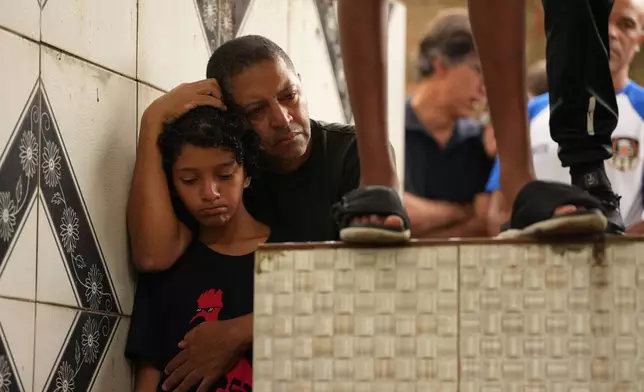 Friends of 11-year-old Bernardo Lopes, who died during heavy rains and flooding, attend his burial in Juiz de Fora, Minas Gerais state, Brazil, Wednesday, Feb. 25, 2026. (AP Photo/Silvia Izquierdo)