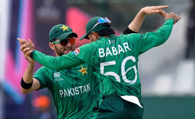 Pakistan's Babar Azam, right, and teammate Shaheen Shah Afridi celebrate after taking a co-ordinated catch to dismiss Netherlands' Michael Levitt during the T20 World Cup cricket match between Netherlands and Pakistan in Colombo, Sri Lanka, Saturday, Feb. 7, 2026. (AP Photo/Eranga Jayawardena)