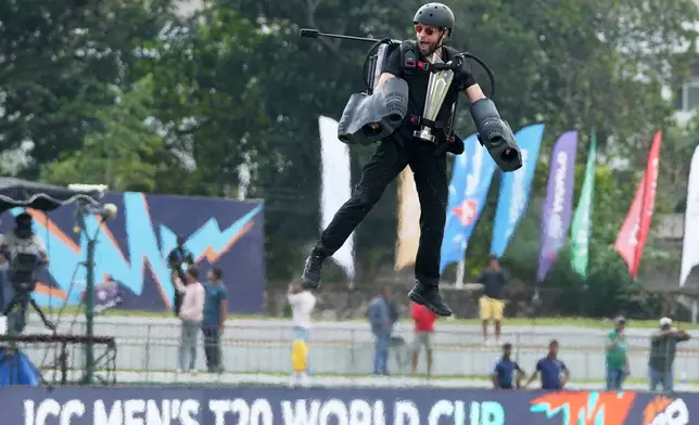 An acrobat flies with the T20 World Cup cricket trophy around the stadium before the start of the opening match between Netherlands and Pakistan in Colombo, Sri Lanka, Saturday, Feb. 7, 2026. (AP Photo/Eranga Jayawardena)