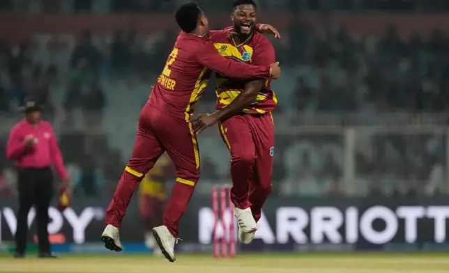 West Indies' Romario Shepherd ,right, celebrates with Shimron Hetmyer the wicket of Scotland's Safyaan Sharif during the T20 World Cup cricket match between Scotland and West Indies in Kolkata, India, Saturday, Feb. 7, 2026. (AP Photo/Bikas Das)