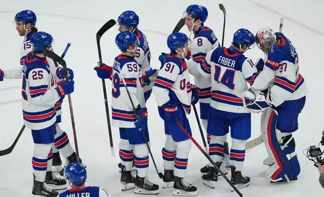 United States players line up to congratulate goalkeeper Connor Hellebuyck (37) after their win over Slovakia in a men's ice hockey semifinal game at the 2026 Winter Olympics in Milan, Italy, Friday, Feb. 20, 2026. (AP Photo/Carolyn Kaster)