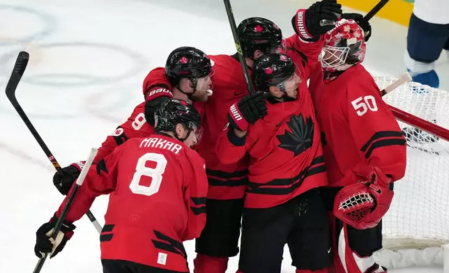 Canada goalkeeper Jordan Binnington (50) is congratulated after Canada's 3-2 win over Finland in a men's ice hockey semifinal game at the 2026 Winter Olympics in Milan, Italy, Friday, Feb. 20, 2026. (AP Photo/Carolyn Kaster)