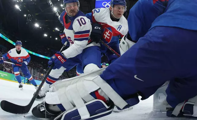 United States' JT Miller (10) challenges with Slovakia's Martin Fehervary (42) during a men's ice hockey semifinal game between the United States and Slovakia at the 2026 Winter Olympics, in Milan, Italy, Friday, Feb. 20, 2026. (Bruce Bennett/Pool Photo via AP)