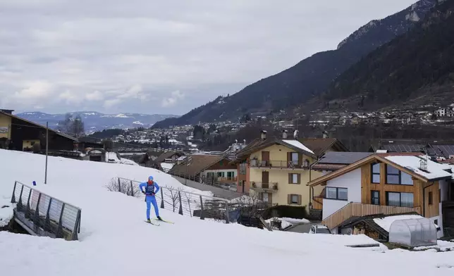 A cross-country skiing athlete from Italy skis through the village of Ziano di Fiemme during a non-competition day at the 2026 Winter Olympics, near the course in Tesero, Italy, Monday, Feb. 9, 2026. (AP Photo/Armando Franca)