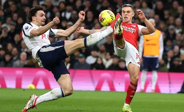Tottenham's Joao Palhinha, left, and Arsenal's Leandro Trossard challenge for the ball during the English Premier League soccer match between Tottenham Hotspur and Arsenal in London, Sunday, Feb. 22, 2026.(AP Photo/Ian Walton)