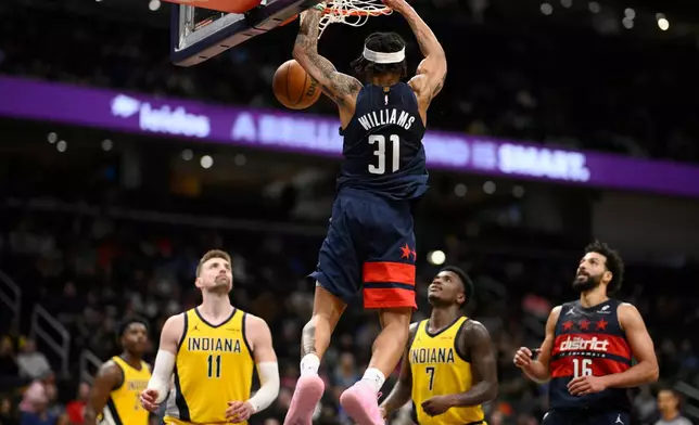 Washington Wizards guard Alondes Williams (31) dunks over Indiana Pacers center Micah Potter (11) and guard Kam Jones (7) during the second half of an NBA basketball game, Friday, Feb. 20, 2026, in Washington. (AP Photo/Nick Wass)