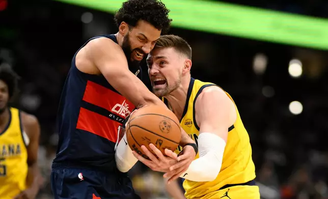 Indiana Pacers center Micah Potter, right, and Washington Wizards forward Anthony Gill, left, battle for the ball during the first half of an NBA basketball game, Friday, Feb. 20, 2026, in Washington. (AP Photo/Nick Wass)