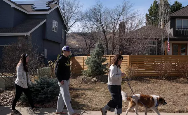 CEO of the Chef Ann Foundation, Mara Fleishman, a winner of this year's Elevate Prize; her son Jake Anderson, center; and daughter Lucy Anderson, left, take their family dog for a walk, Monday, Feb. 16, 2026, in Boulder, Colo. (AP Photo/Rebecca Slezak)