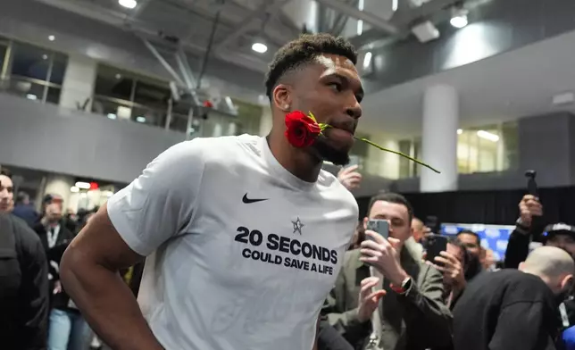 Milwaukee Bucks' Giannis Antetokounmpo walks with a rose in his mouth during the NBA All-Star basketball game media day Saturday, Feb. 14, 2026, in Inglewood, Calif. (AP Photo/Jae C. Hong)