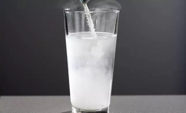 Electrolyte supplements are poured into glass of water Tuesday, Feb. 24, 2026, in Nashville, Tenn. (AP Photo/George Walker IV)